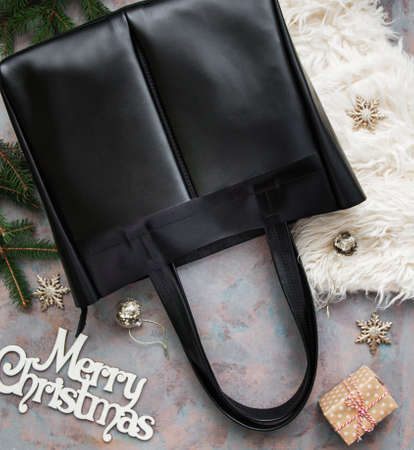 Black leather bag with Christmas decorations - flat layの写真素材
