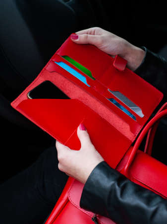 Red leather woman wallet with cards and phone  in hand