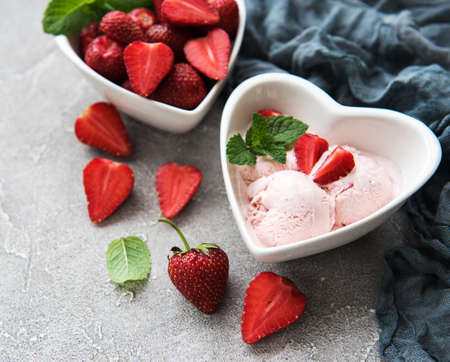 Strawberry ice cream and waffle cone on a stone backgroundの写真素材