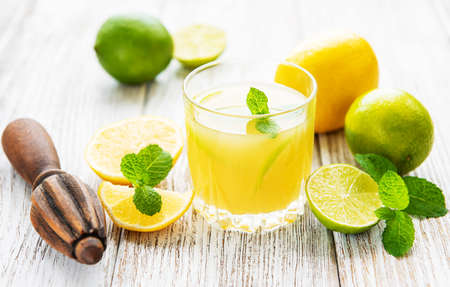 Glass with fresh lemon juice on a old wooden tableの写真素材