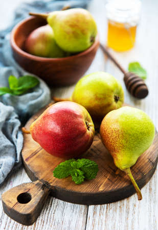 Pears on a wooden board on a old tableの写真素材