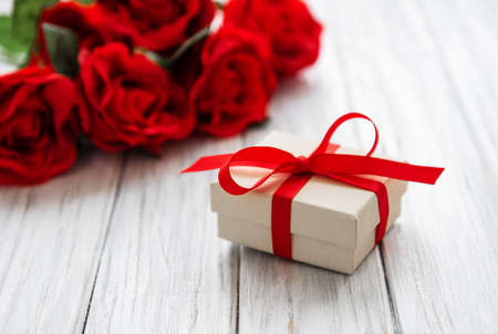 valentine gift box and roses bouquet on a old wooden backgroundの写真素材