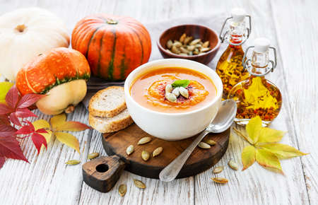 Bowl of pumpkin soup on rustic wooden backgroundの写真素材