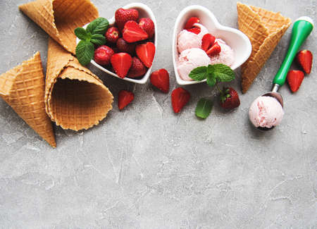 Strawberry ice cream and waffle cone on a stone backgroundの写真素材