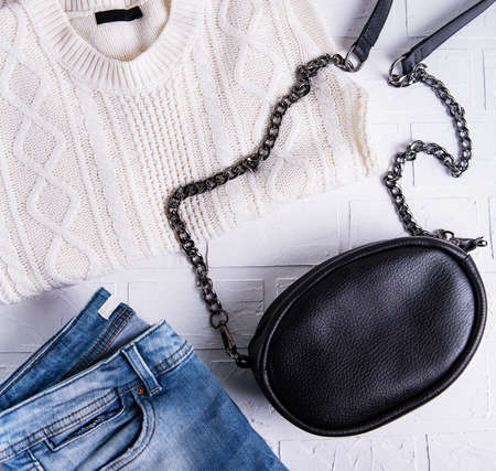 Black leather bag and womens clothing, jeans and sweaterの写真素材