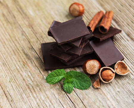 Chocolate with hazelnuts  on a old wooden tableの写真素材