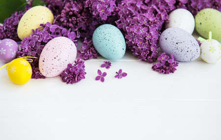 Easter eggs  with lilac flowers on a white wooden backgroundの写真素材