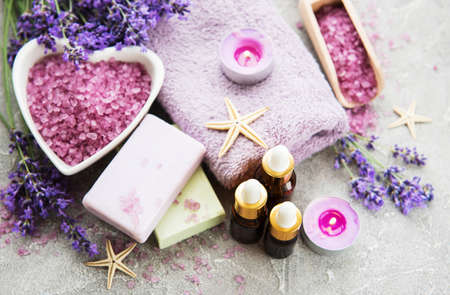 Heart-shaped bowl with sea salt, soap and fresh lavender flowers on a concrete backgroundの写真素材