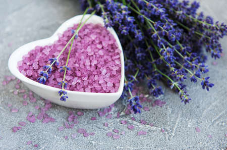 Heart-shaped bowl with sea salt  and fresh lavender flowers on a stone  backgroundの写真素材