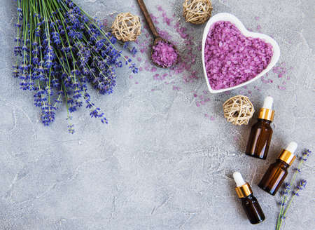 Heart-shaped bowl with sea salt and fresh lavender flowers on a concrete backgroundの写真素材