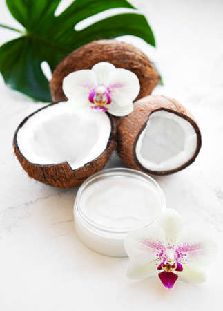 Fresh coconut oil and coconuts on a white marble backgroundの写真素材