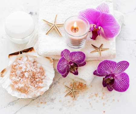 Spa products with orchid flowers on a white marble backgroundの写真素材