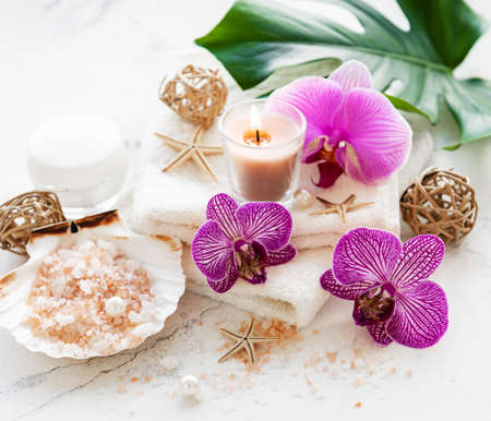 Spa products with orchid flowers on a white marble backgroundの写真素材