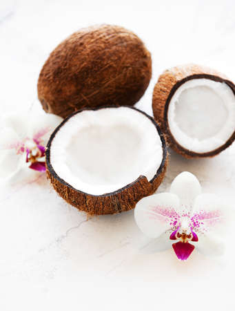 Coconuts with orchid flowers on a old wooden  background