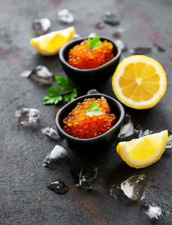 Red caviar in bowls on a old black backgroundの写真素材