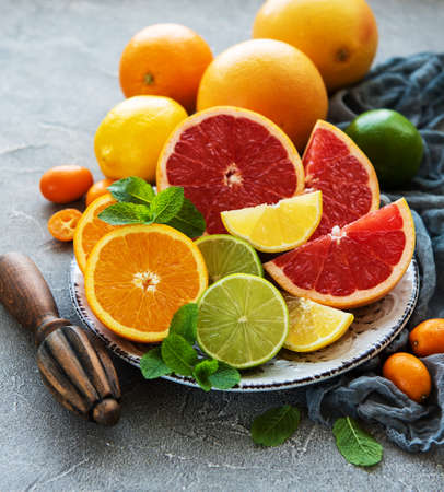 Plate with citrus fresh fruits on a concrete backgroundの写真素材