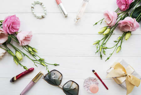 Flowers and cosmetics on a white wooden table, flat layの写真素材