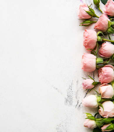 Frame with pink roses on a white marble background