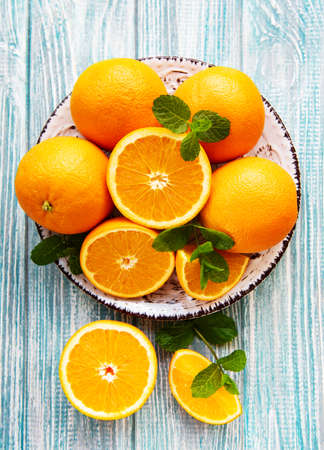 Fresh orange fruits on a old wooden tableの写真素材