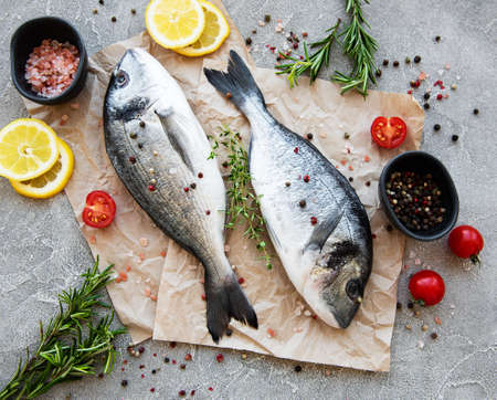 Fresh fish dorado. Dorado and ingredients for cooking on a table.の写真素材