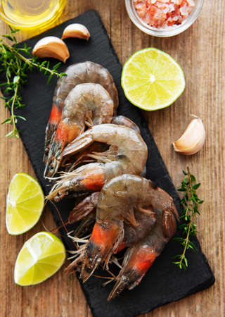 Fresh raw  prawns and spices on  wooden tableの写真素材