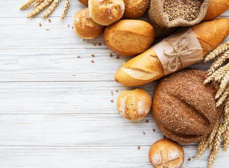 assortment of baked bread on white wooden backgroundの写真素材