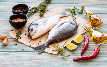 Fresh fish dorado. Dorado and ingredients for cooking on a table.の写真素材