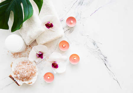 Spa products with orchid flowers on a white marble backgroundの写真素材