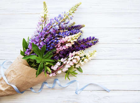 Pink and purple lupine flowers border on a old white wooden backgroundの写真素材