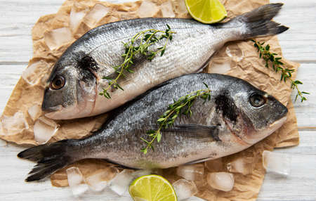 Fresh fish dorado. Dorado and ingredients for cooking on a table.の写真素材