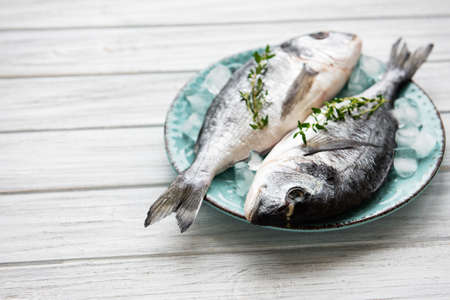 Fresh fish dorado. Dorado and ice for cooking on a table.