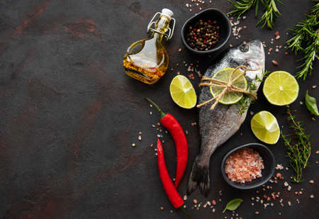 Fresh fish dorado. Dorado and ingredients for cooking on a table.の写真素材