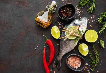 Fresh fish dorado. Dorado and ingredients for cooking on a table.の写真素材