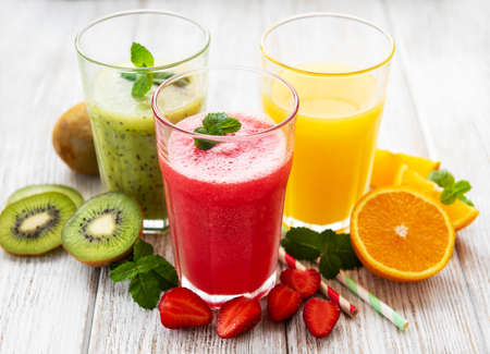 Healthy fruit smoothies and fresh fruits on a old wooden tableの写真素材