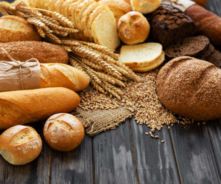 Assortment of baked bread on old wooden  backgroundの写真素材