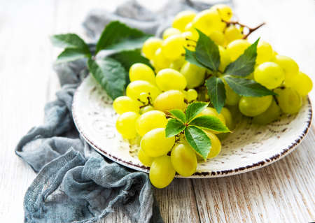 Fresh green grape  on a old wooden tableの写真素材
