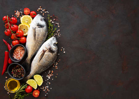 Fresh fish dorado. Dorado and ingredients for cooking on a table.