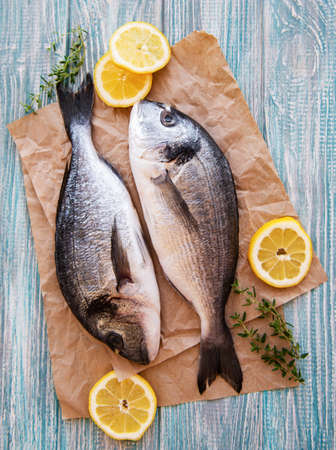 Fresh fish dorado. Dorado and ingredients for cooking on a table.の写真素材