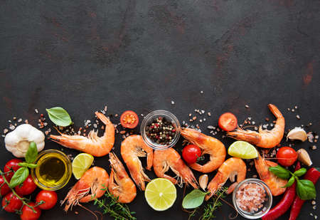 Fresh seafood - shrimps  with vegetables, herbs and spices on blackの写真素材