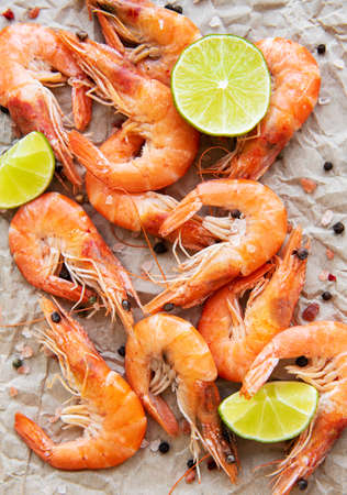 Shrimps served with lemons and spices on a paperの写真素材