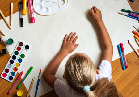 Little girl drawing with color pen in paper on floor  at home with copy spaceの写真素材