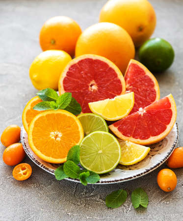 Plate with citrus fresh fruits on a concrete backgroundの写真素材