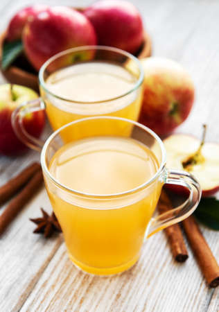 Apple cider with cinnamon sticks on a old wooden tableの写真素材