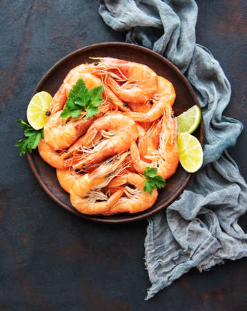 Shrimps served with lemons and spices on a black backgroundの写真素材