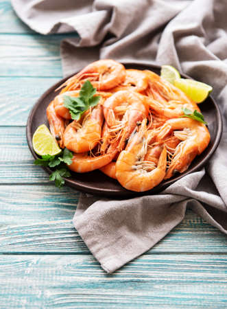 Shrimps served with lemons and spices on a wooden  backgroundの写真素材