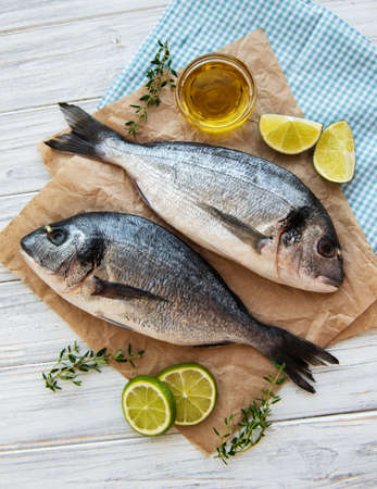 Fresh fish dorado. Dorado and ingredients for cooking on a table.の写真素材