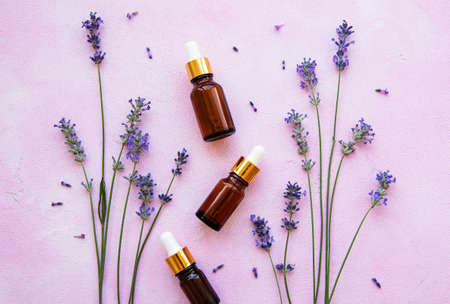 Flat lay composition with lavender flowers and natural cosmetic on pink concrete backgroundの写真素材