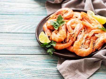 Shrimps served with lemons and spices on a wooden  backgroundの写真素材