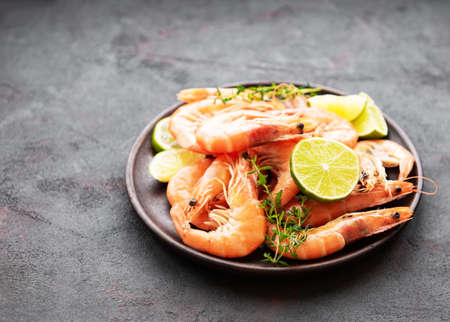 Shrimps served with lemons and spices on a black backgroundの写真素材