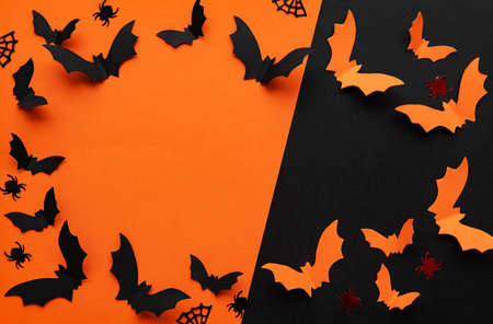 Black and orange paper bats flying over black and orangeの写真素材